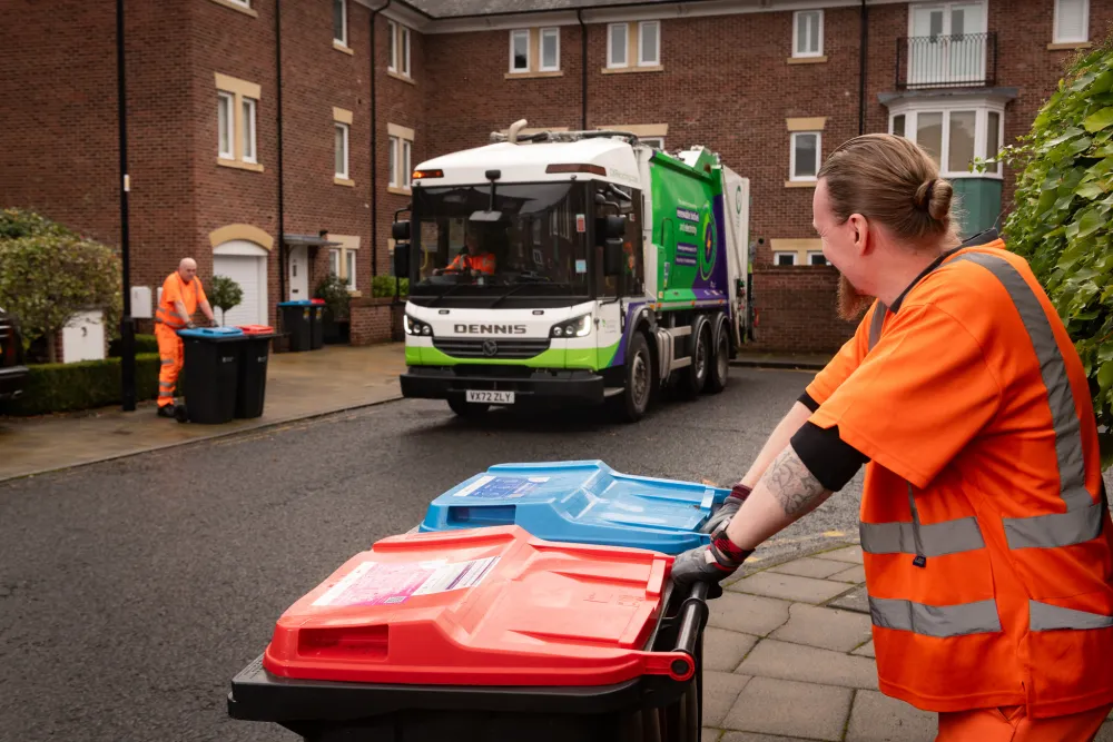 A recycling collection crew awaits at the side of a residential street